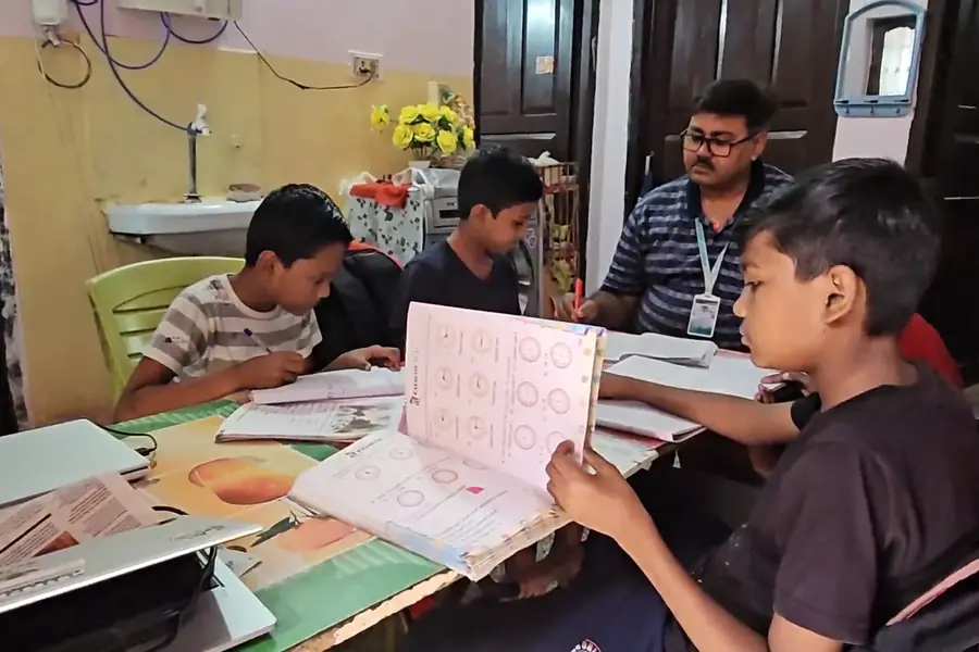Tutor teaching junior students in the evening at Maa Gayatri Boys Hostel